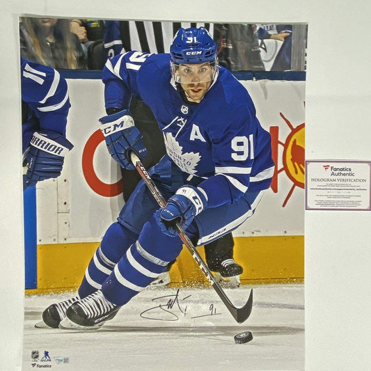 Signed John Tavares Toronto Maple Leafs 16x20 photo showing player in blue jersey number 91 skating with puck, Fanatics authentication hologram visible.