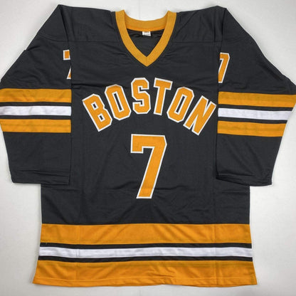 Black and gold Boston hockey jersey number 7 displayed flat against white background, showing front with "BOSTON" text and sleeve stripes.