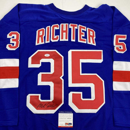 Blue New York Rangers hockey jersey number 35 with "RICHTER" across chest, signed in black marker, displaying PSA/DNA certificate of authenticity below.