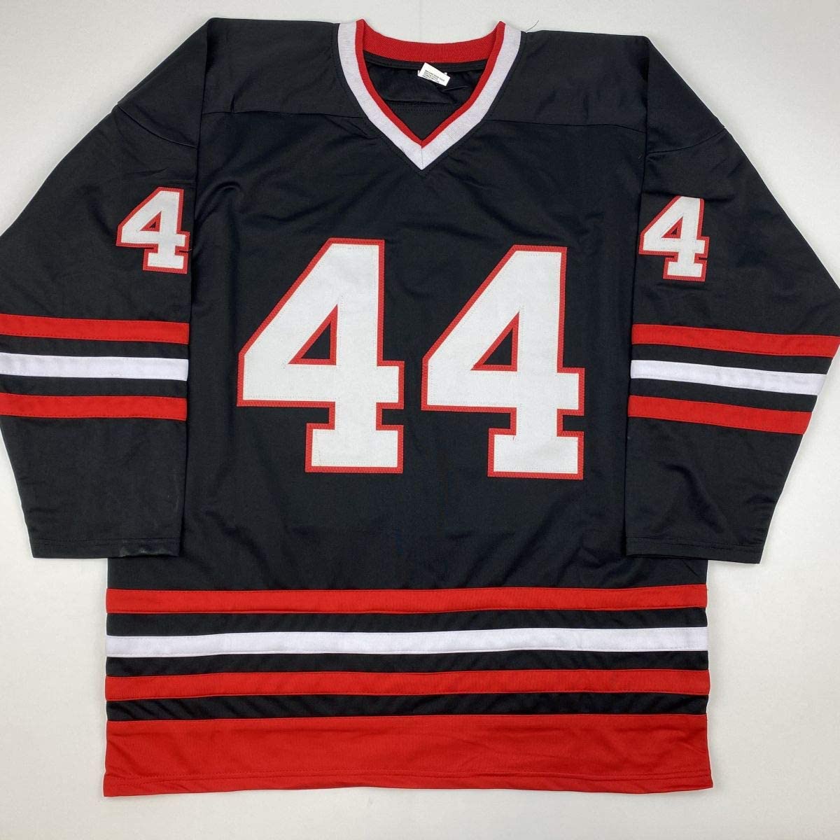 Black hockey jersey with red and white stripes, number 44 in white on chest and shoulders, displayed flat on white background.