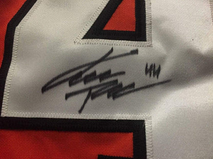 Close-up of autographed signature on white fabric of Philadelphia Flyers orange and black hockey jersey.