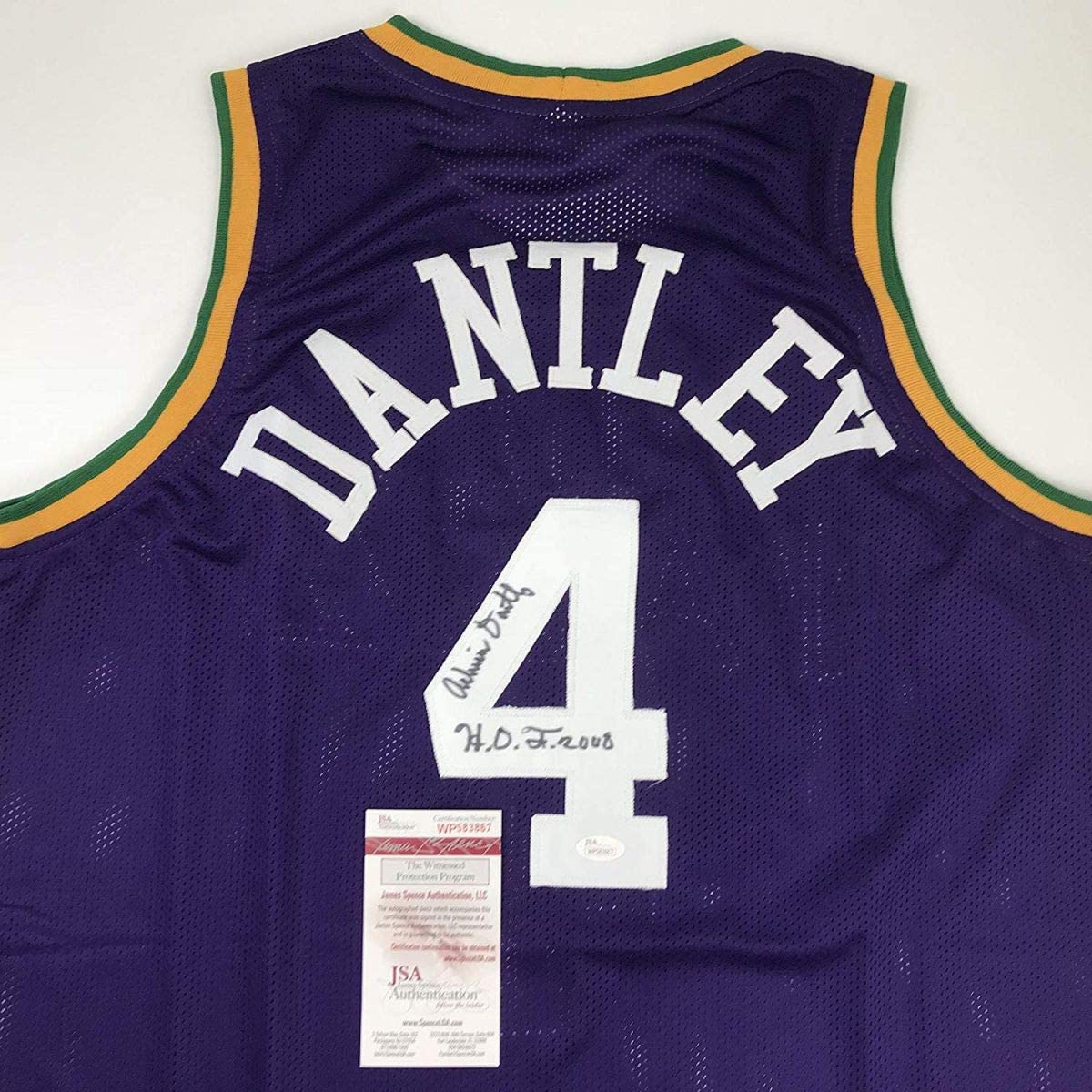 Back view of purple basketball jersey with "DANTLEY" and number 4 in white, featuring green and gold trim, with JSA authentication label and autographed inscription.