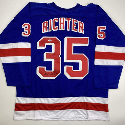 Back view of blue New York Rangers hockey jersey number 35 with "RICHTER" name and red-white stripes, displaying an autographed signature on the number.