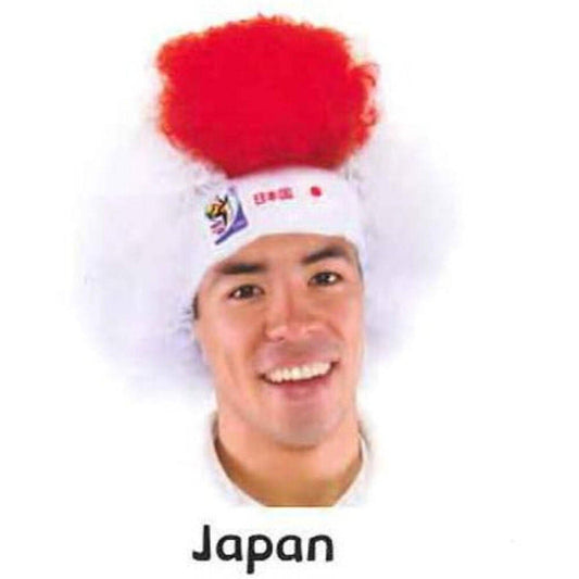 Man wearing red fluffy afro wig with white headband displaying Japanese flag logo, smiling at camera.