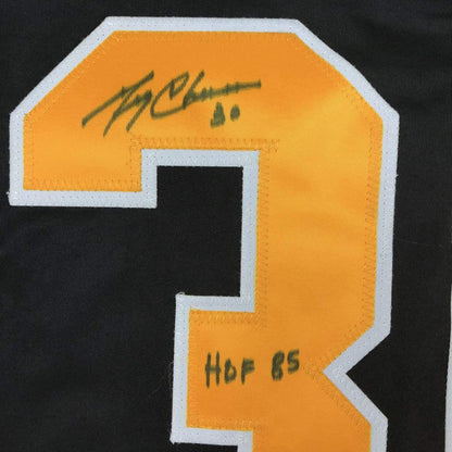 Close-up of orange and white jersey number patch with handwritten signature and "HoF 65" text in black ink.
