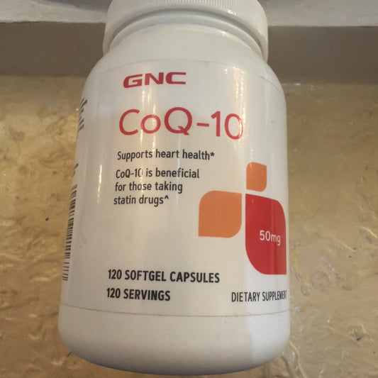 White plastic bottle of GNC CoQ-10 50mg supplement with red and orange label displayed on countertop, front-facing view.