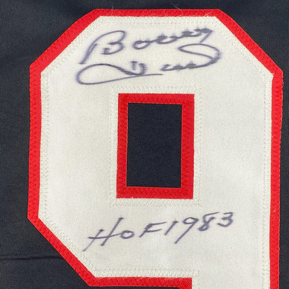 Close-up of red fabric jersey patch with handwritten blue signature and "HOF 1983" inscription on cream-colored backing.