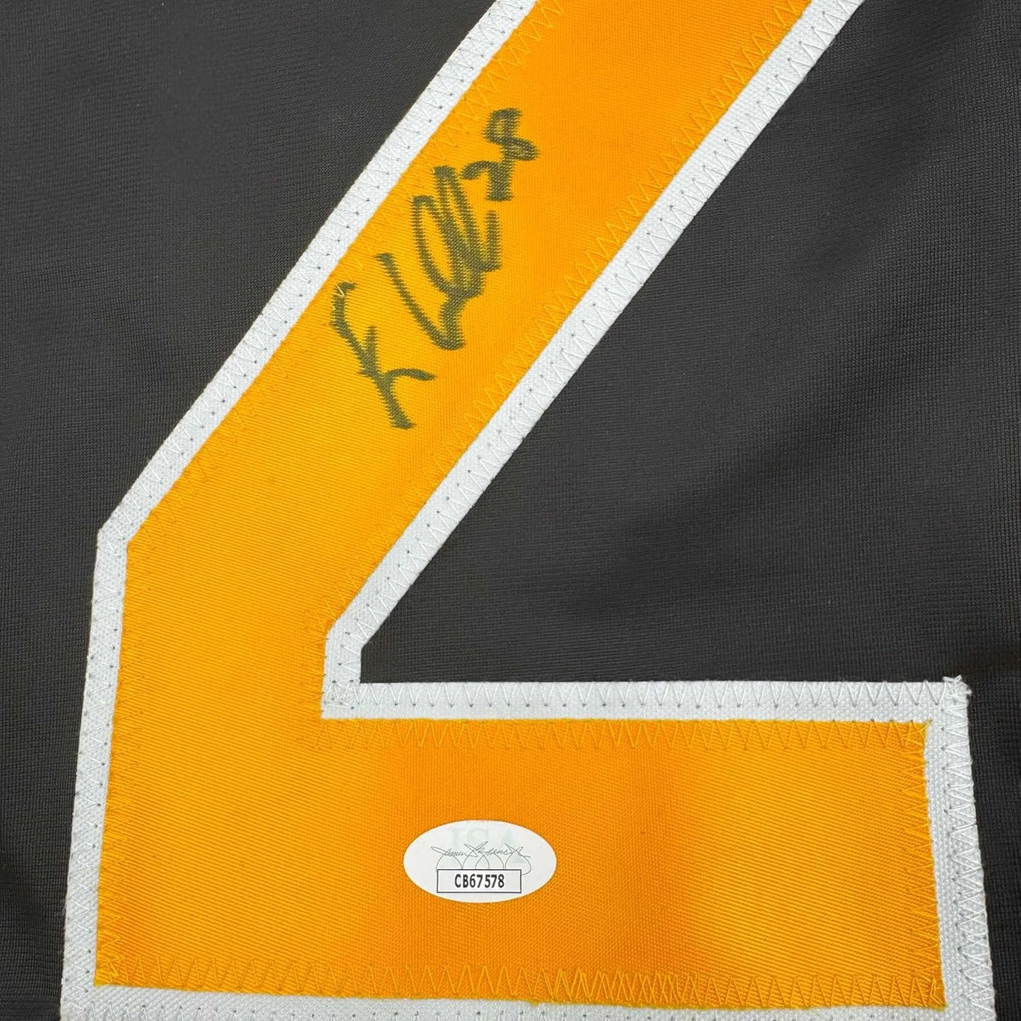 Close-up of yellow hockey jersey stripe with handwritten signature and JSA authentication sticker displaying certificate number C867578.