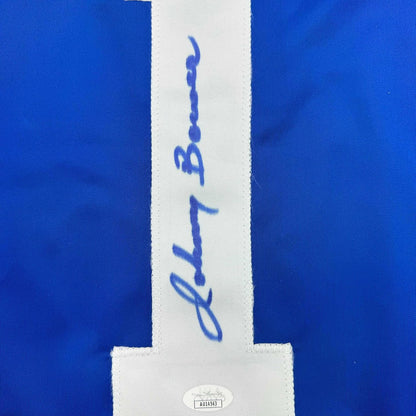 Close-up of white center stripe on blue jersey showing handwritten signature and authentication hologram label.