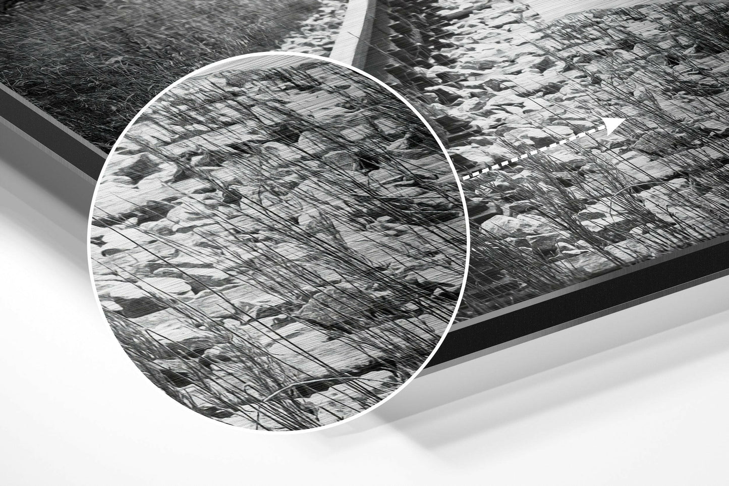 Close-up detail of brushed aluminum dibond wall art showing circular mirror reflection of bare tree branches in black and white.