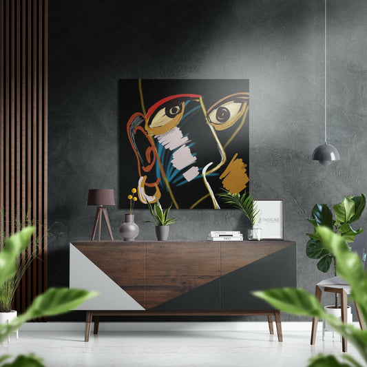 Modern interior with cubist face artwork featuring red glasses and gold accents displayed above wooden console table.
