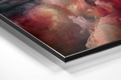 Angled perspective view of brushed aluminum Dibond wall art featuring red and pink clouds with white highlights and visible layered edge construction.
