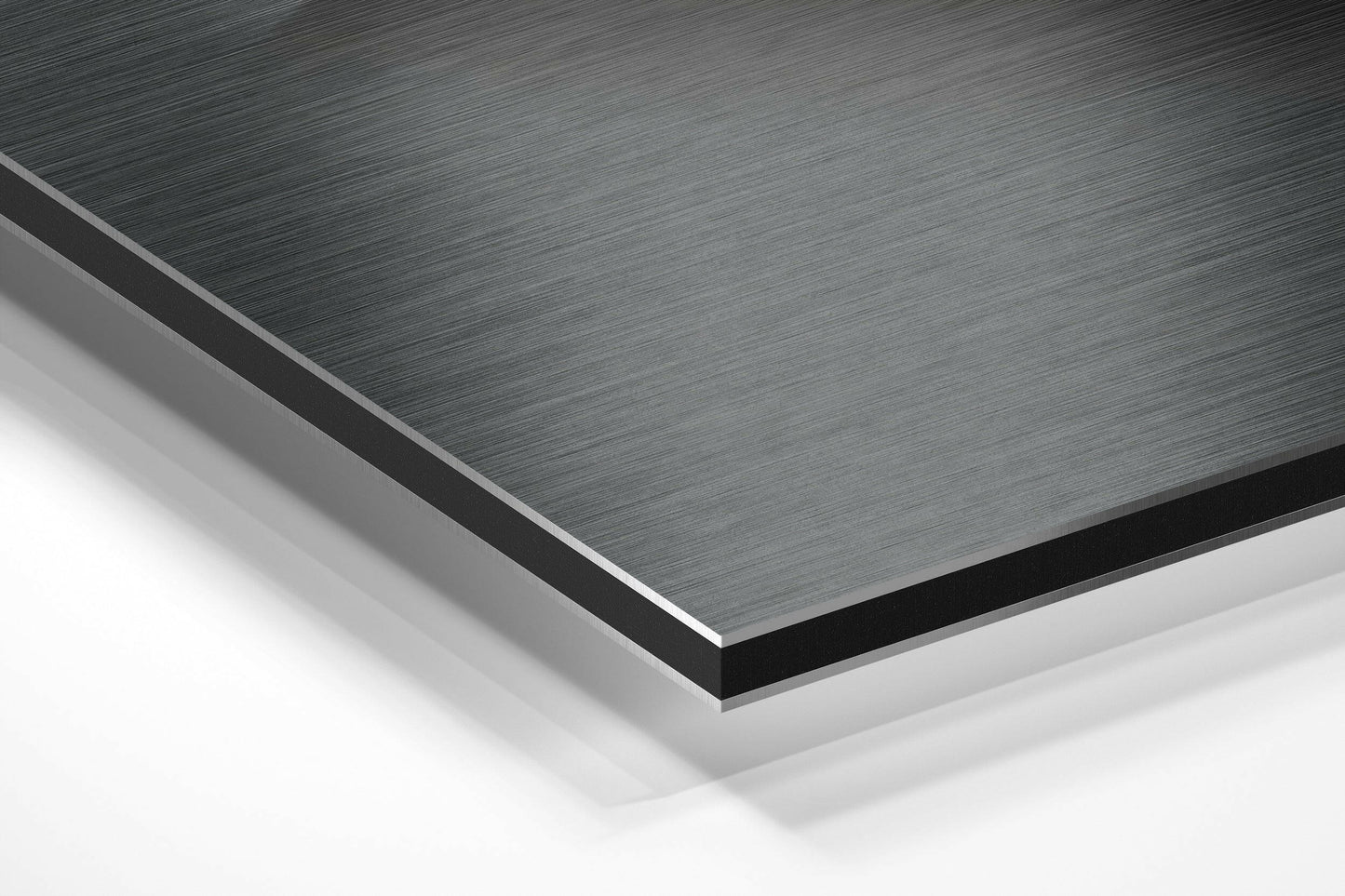 Close-up angled view of stacked Dibond panels showing brushed aluminum surface texture in gray and white layers.