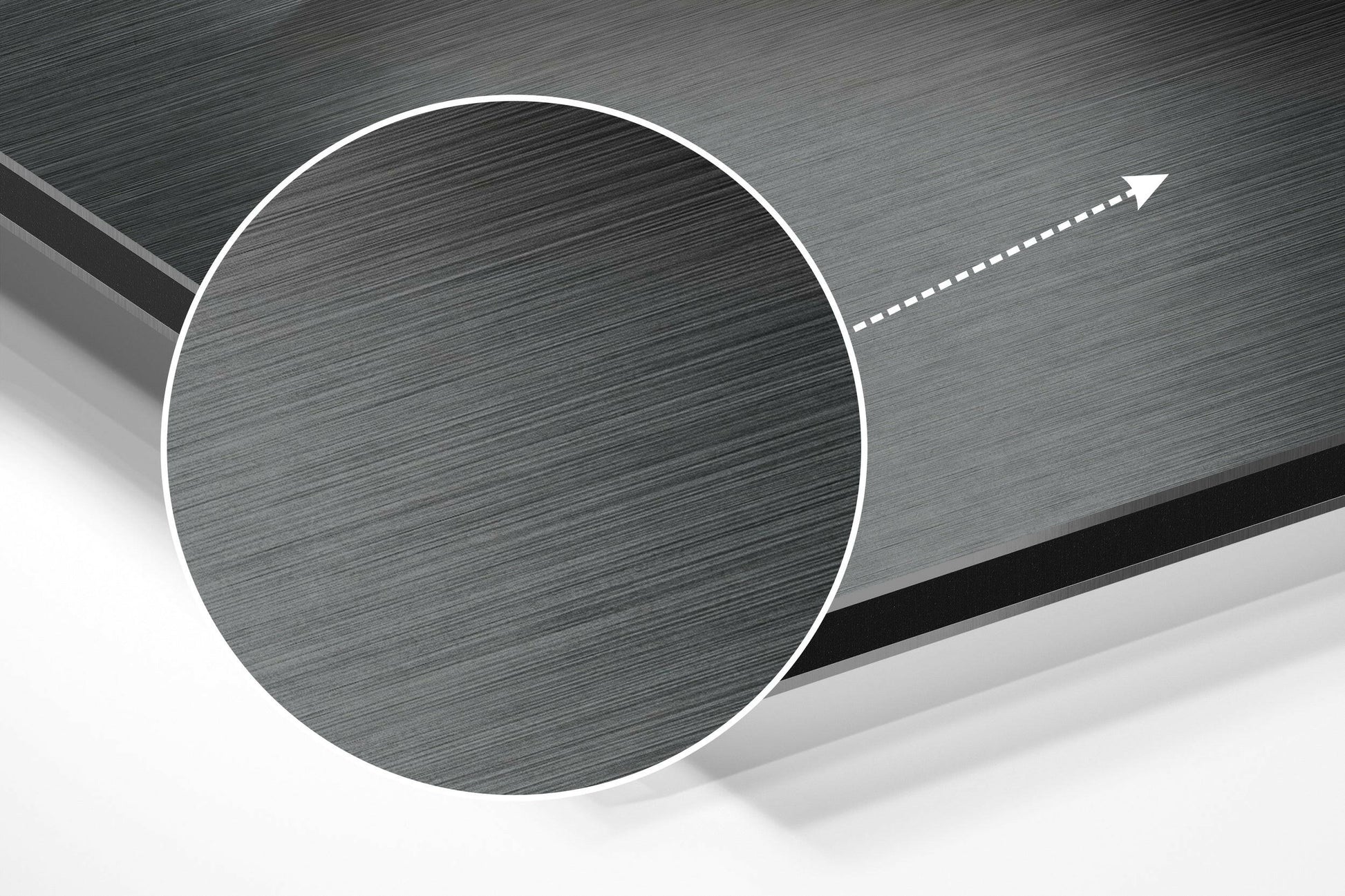 Angled close-up of brushed aluminum circular wall art with white border and directional arrow overlay on gray textured surface.