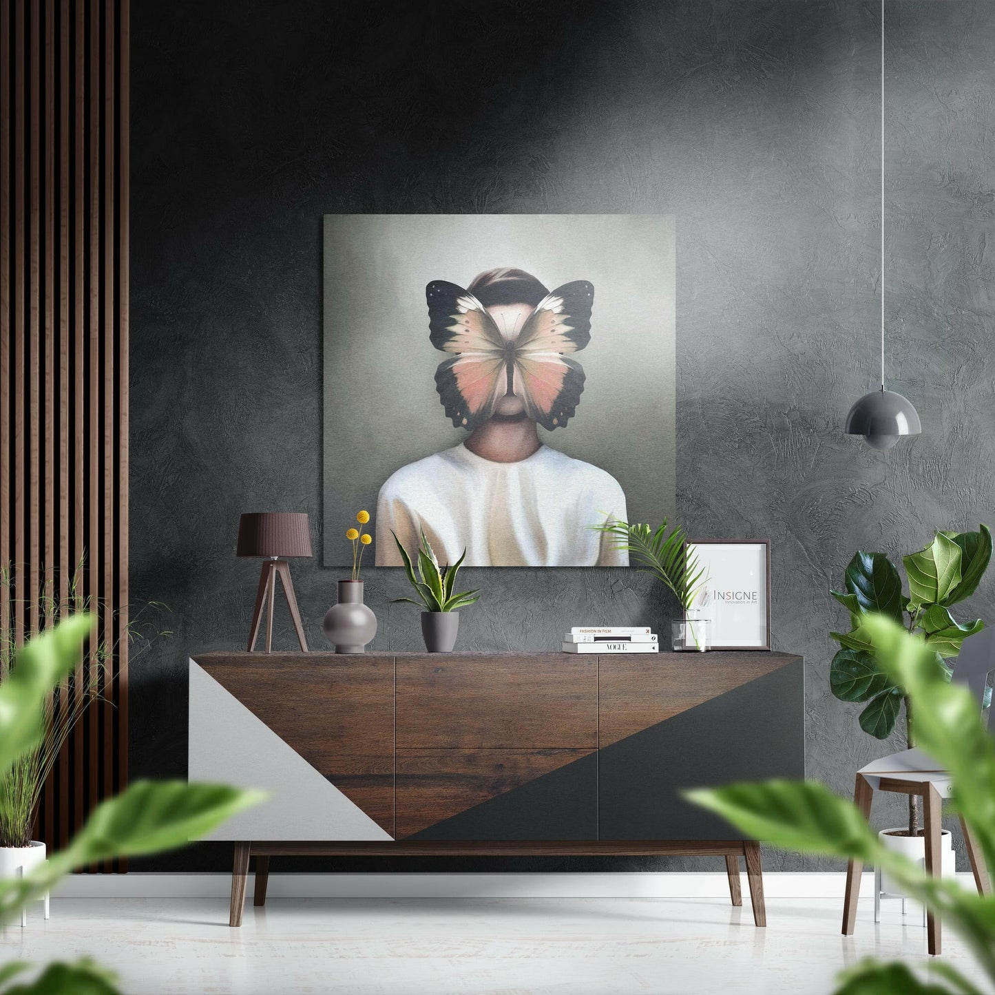 Modern interior display featuring butterfly face wall art hung above a wooden console table with potted plants and decorative objects.