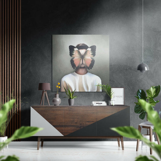 Modern interior display featuring butterfly face wall art hung above a wooden console table with potted plants and decorative objects.