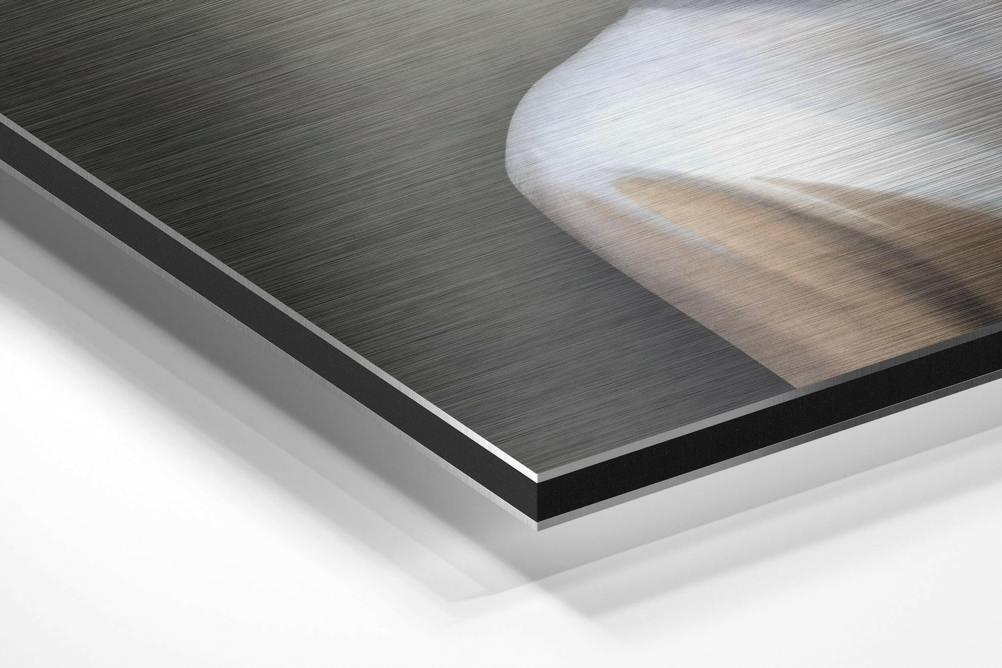 Close-up angled view of layered Dibond panels showing brushed aluminium surface with white backing and black edge detail.