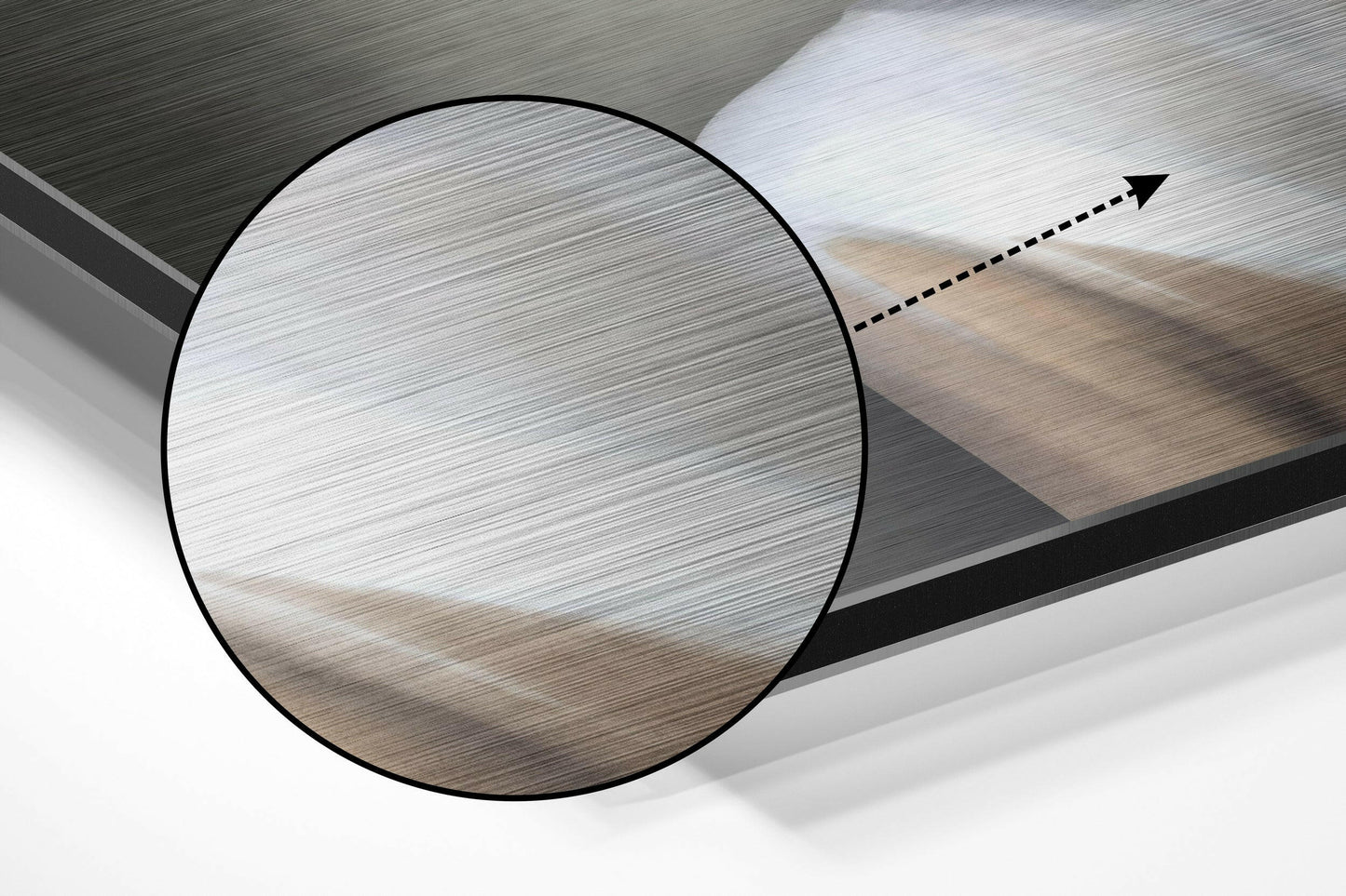 Close-up angled view of brushed aluminium Dibond wall art showing circular detail with directional arrow indicator on textured metallic surface.