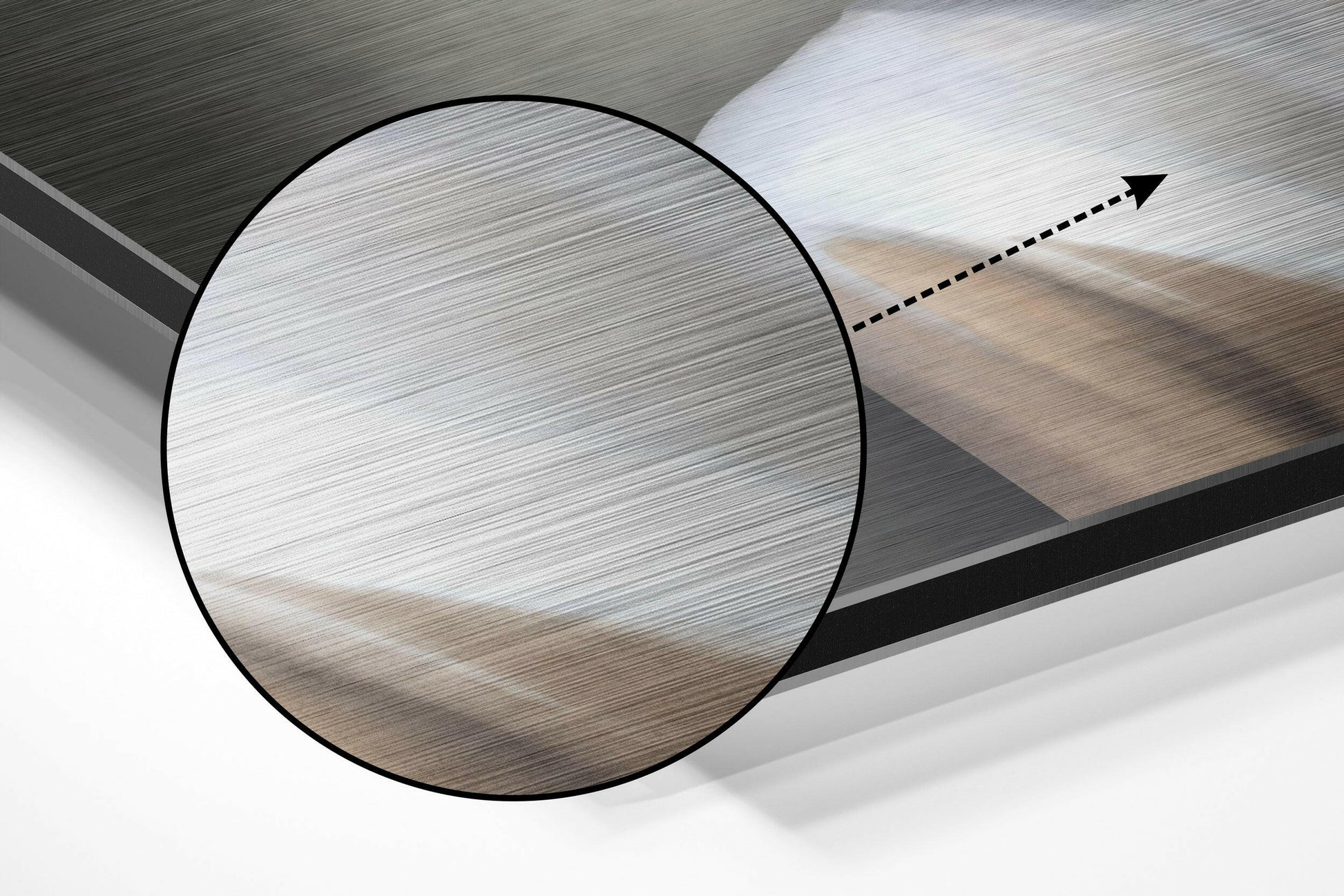 Close-up angled view of brushed aluminium Dibond wall art showing circular detail with directional arrow indicator on textured metallic surface.