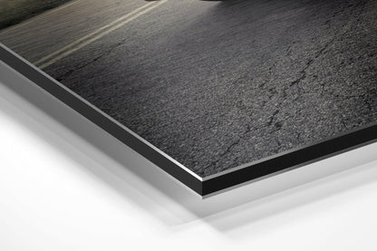 Close-up angled view of layered Dibond panel showing textured dark gray surface with white base layer and black edge trim.