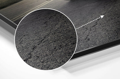 Close-up detail of asphalt road texture with white dashed center line and directional arrow on brushed aluminium Dibond wall art.