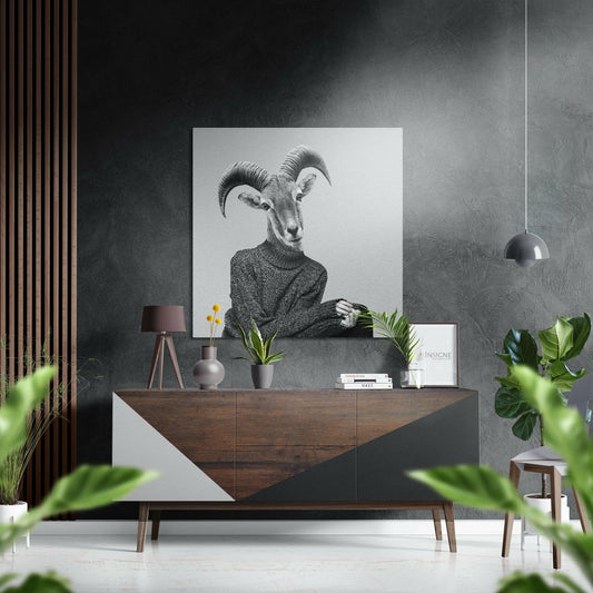 Black and white goat-headed figure in sweater displayed above wooden dresser in modern interior setting with plants and accessories.