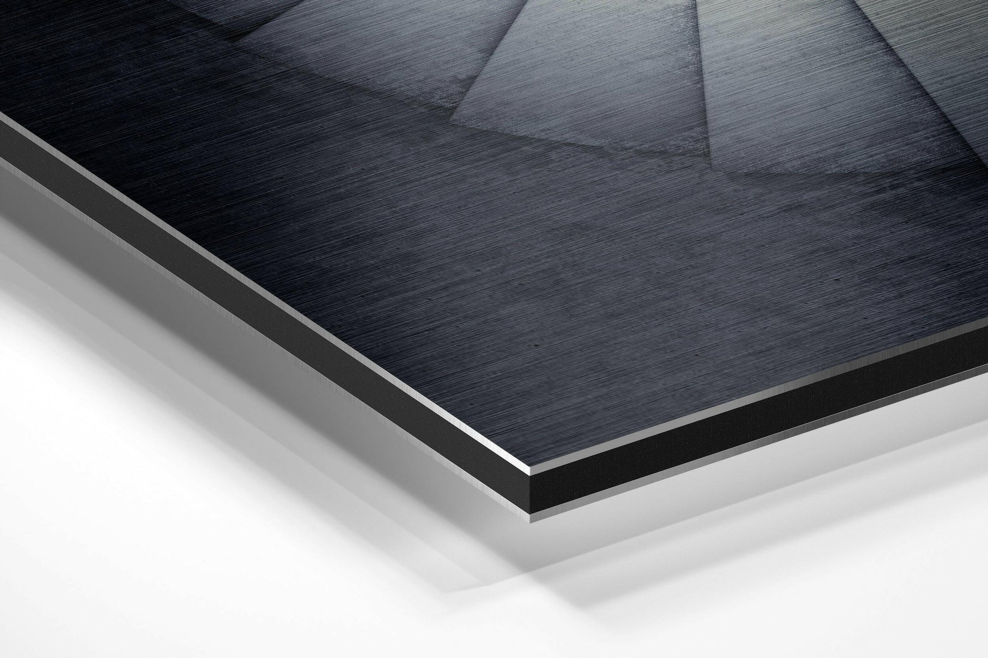 Close-up angled view of layered Dibond wall art showing brushed black aluminum surface with white and gray backing layers.