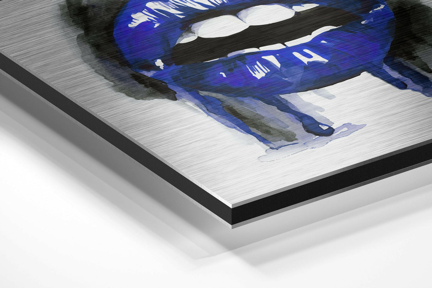 Angled view of brushed aluminium Dibond wall art displaying blue lips with white teeth on white background, showing layered edge construction.