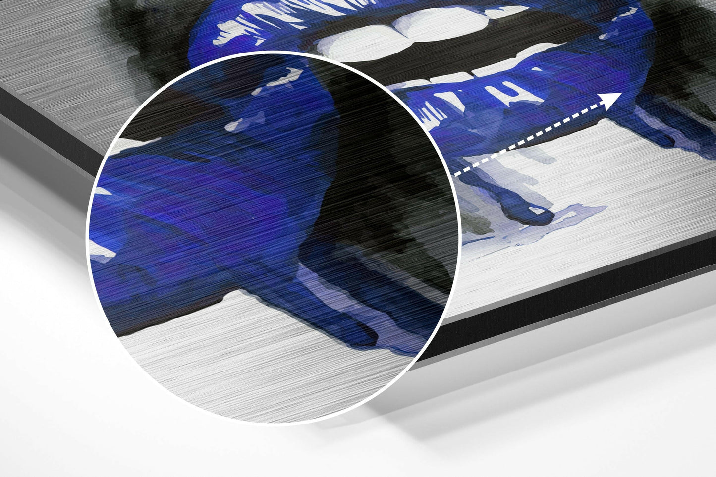 Close-up angled view of blue and white lips design on brushed aluminium surface with magnified circular detail overlay.