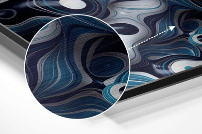 Close-up detail of brushed aluminium wall art showing swirling blue, teal, and white abstract patterns with circular magnified section and directional arrow.