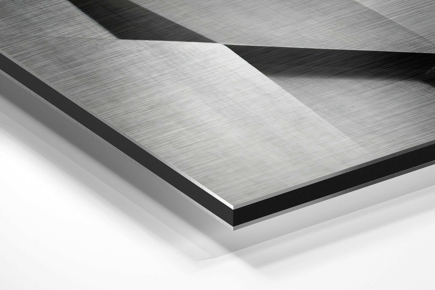 Close-up angled view of layered brushed aluminum and black dibond panels showing geometric folded surfaces with directional texture.