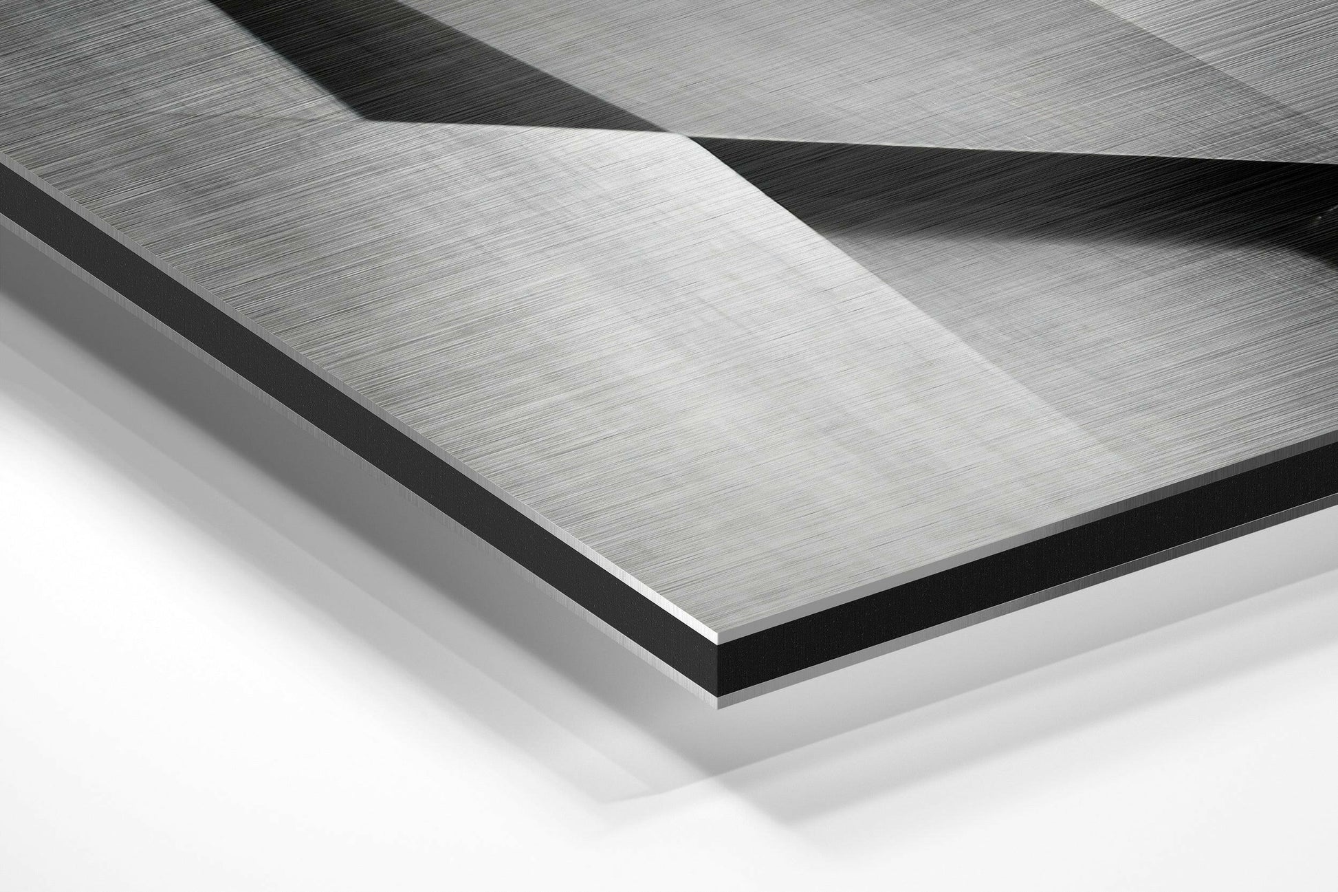 Close-up angled view of layered brushed aluminum and black dibond panels showing geometric folded surfaces with directional texture.