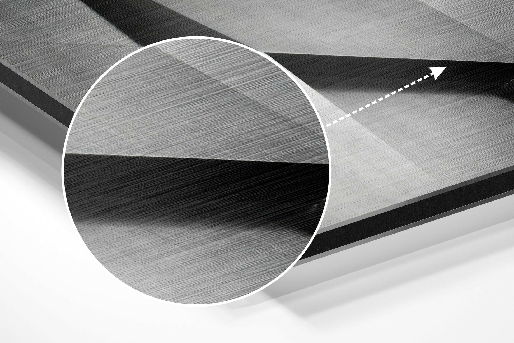Close-up of brushed aluminum circular panel showing metallic grey surface texture with directional arrow indicator on geometric background.