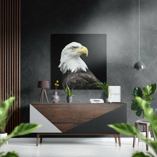 Bald eagle aluminum wall art displayed above a wooden console table in a modern gray interior with plants and pendant lighting.