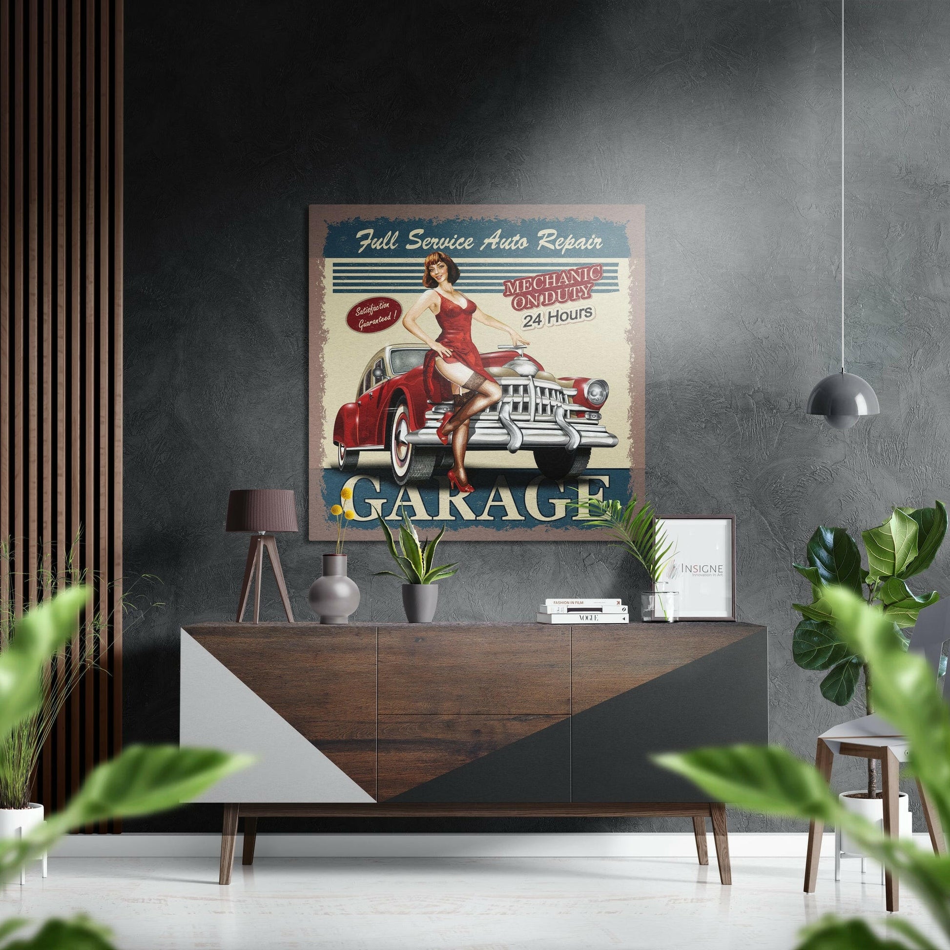 Vintage "Full Service Auto Repair Garage" metal sign displayed above a wooden dresser in a modern interior with plants and pendant lighting.