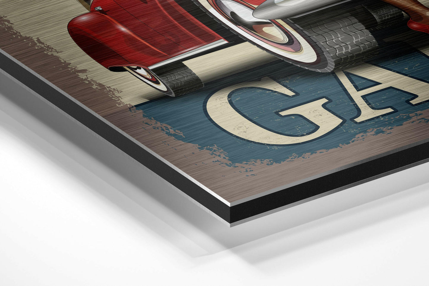 Close-up angled view of brushed aluminium Dibond wall art showing red vintage car, blue wooden background, cream lettering, and layered mounting edge.