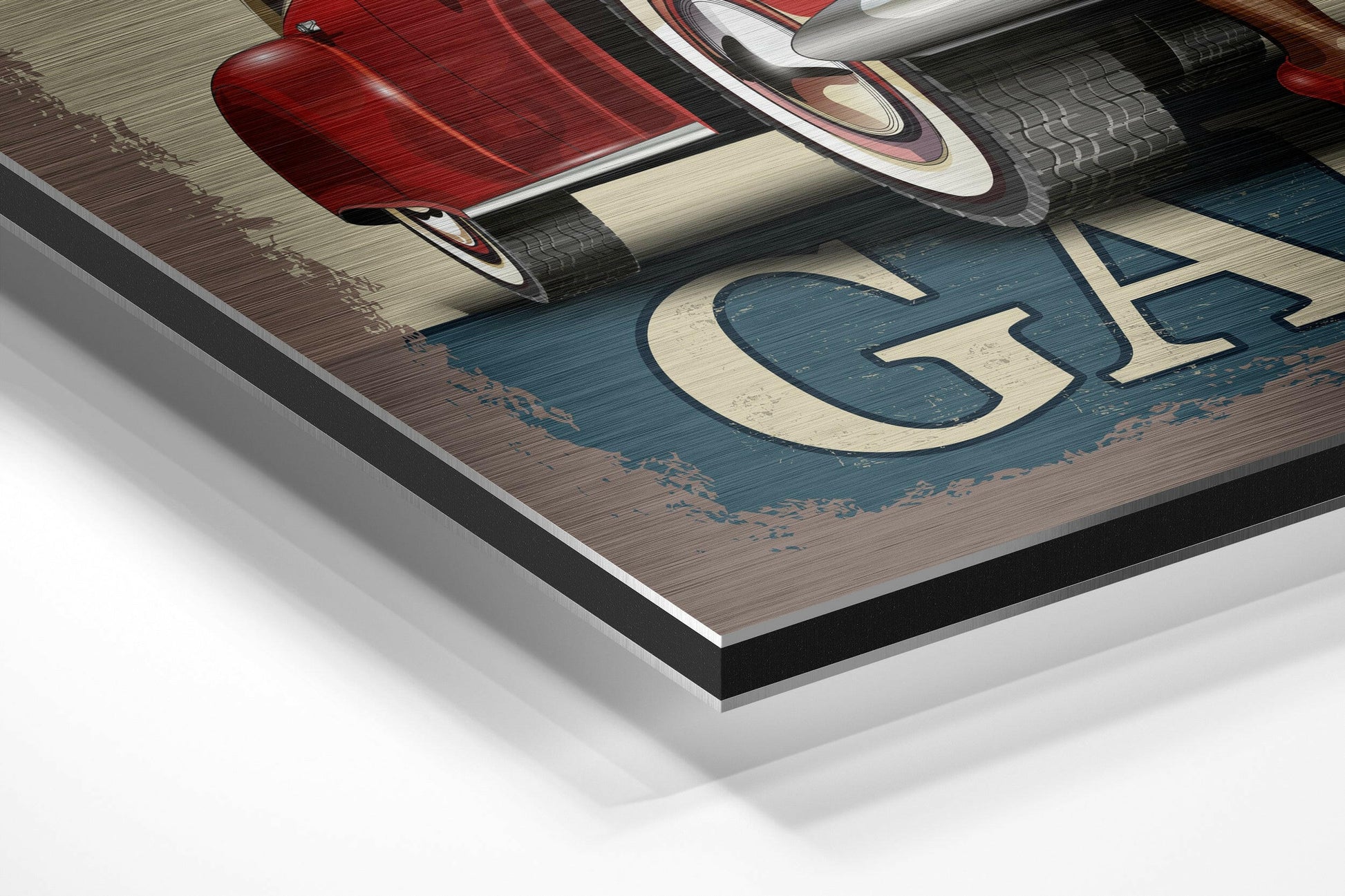 Close-up angled view of brushed aluminium Dibond wall art showing red vintage car, blue wooden background, cream lettering, and layered mounting edge.