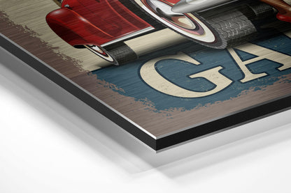Close-up angled view of brushed aluminium Dibond wall art showing red vintage car, blue wooden background, cream lettering, and layered mounting edge.