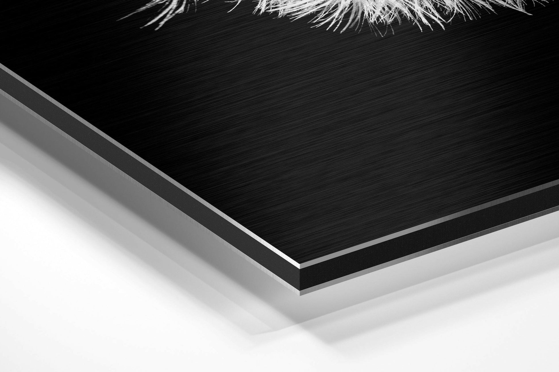 Close-up angled view of layered Dibond wall art showing brushed black aluminum surface with white foam backing and silver edge detail.