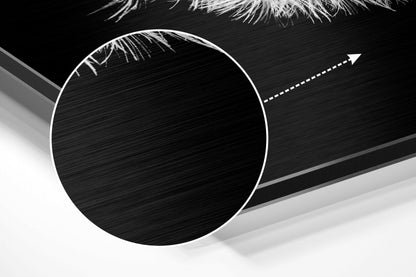 Close-up angled view of brushed aluminum Dibond wall art showing circular white-outlined design with directional arrow on textured black and gray surface.