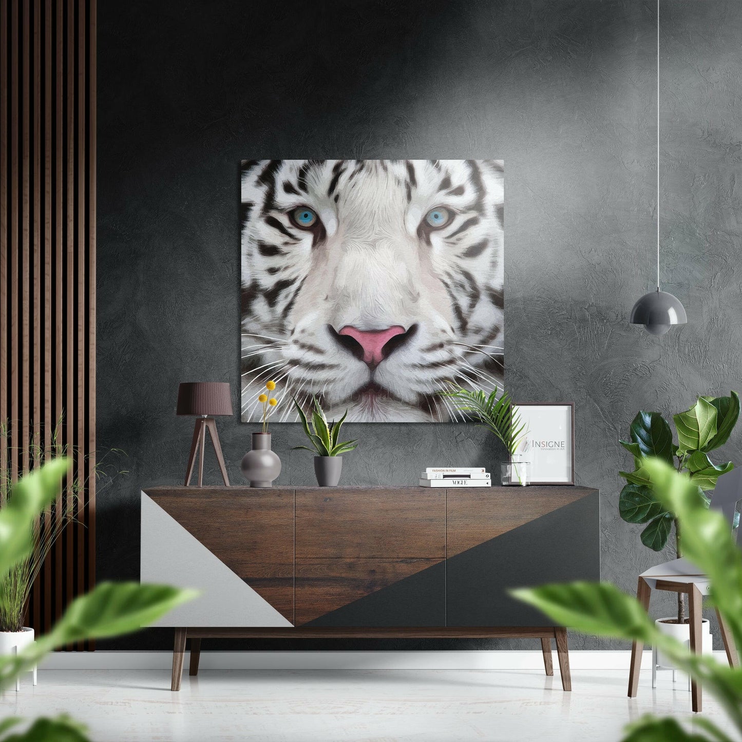 White tiger face with striking blue eyes displayed above wooden sideboard in modern interior with plants and pendant lamp.