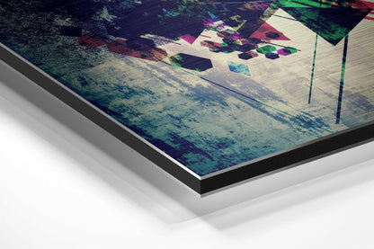 Angled perspective view of brushed aluminium Dibond wall art displaying abstract geometric shapes in magenta, green, and blue tones on textured surface.