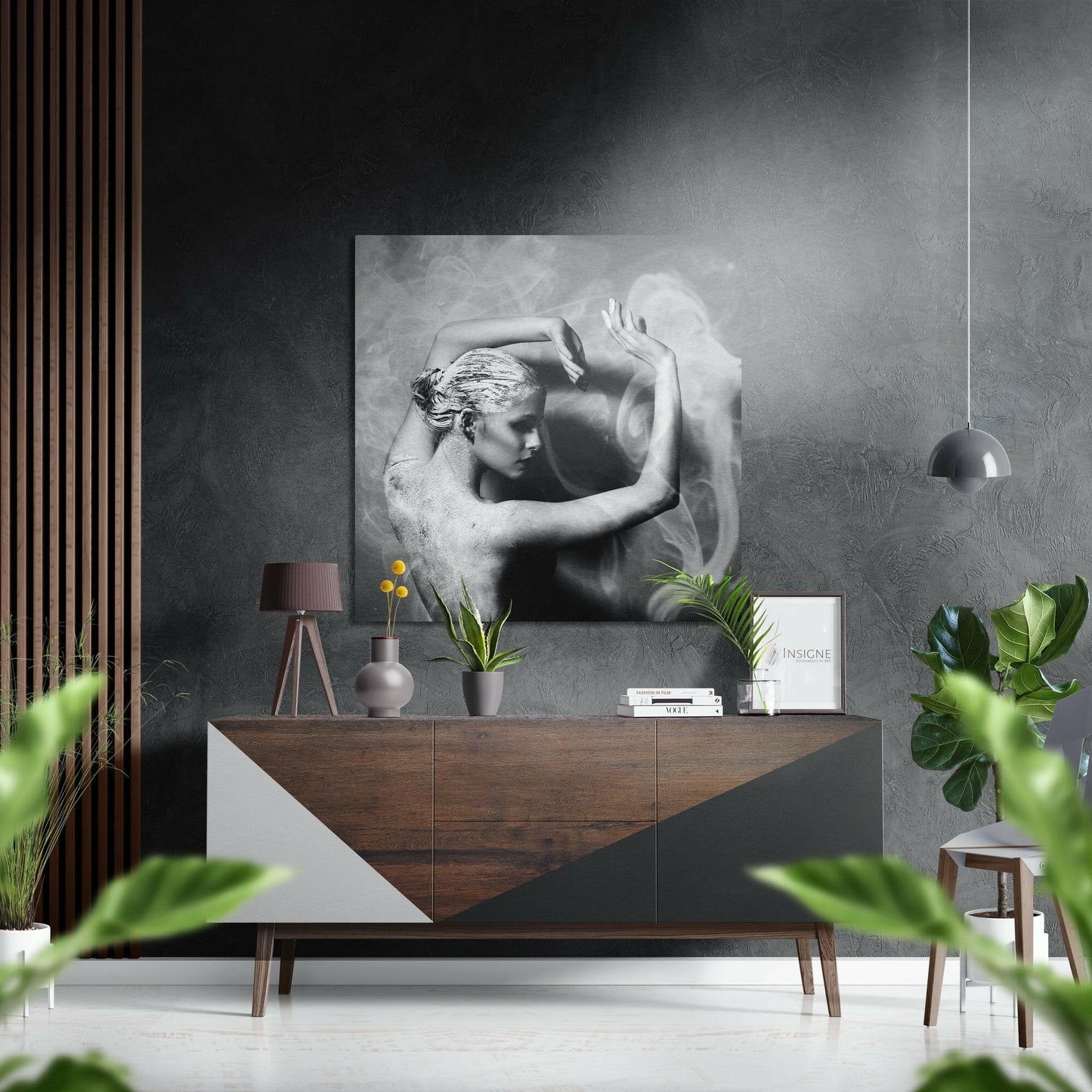 Black and white aluminium wall art depicting a sculptural male figure with raised arms, displayed above a wooden sideboard in a minimalist interior setting.