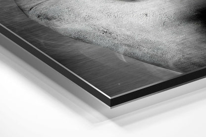 Close-up angled view of brushed aluminum Dibond panel edge showing layered black and white material construction and brushed metal surface texture.