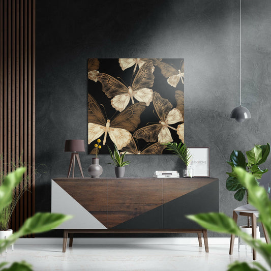 Gold and cream butterflies on black background displayed above wooden dresser in modern interior setting.