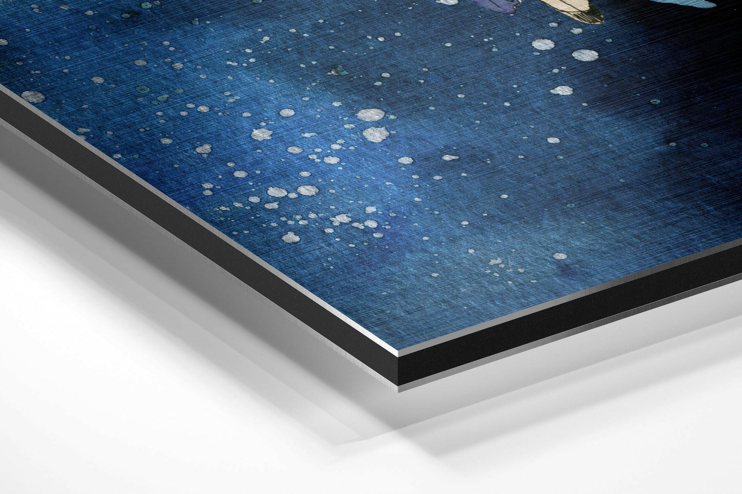 Close-up angled view of Dreamcatcher brushed aluminum Dibond wall art showing blue textured surface with white circular bokeh details and black edge trim.