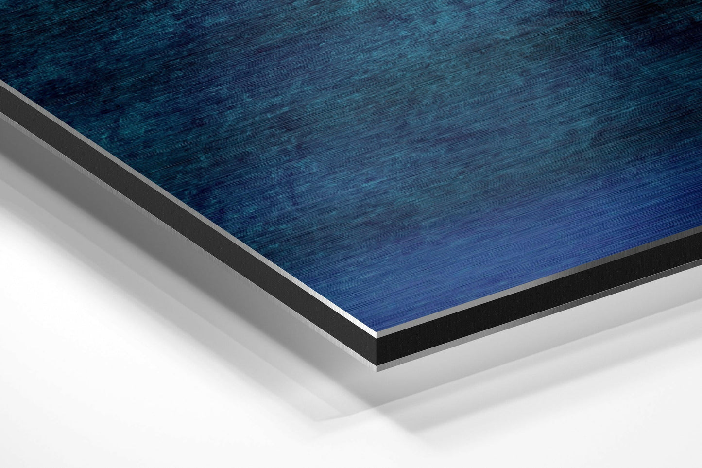 Close-up angled view of layered blue brushed aluminum dibond with gray and black borders against white background.
