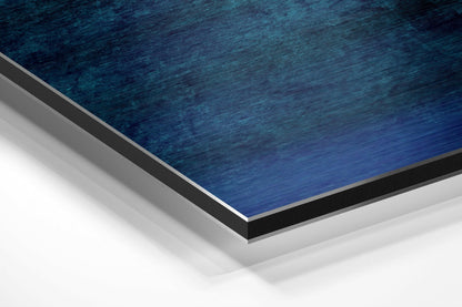 Close-up angled view of layered blue brushed aluminum dibond with gray and black borders against white background.