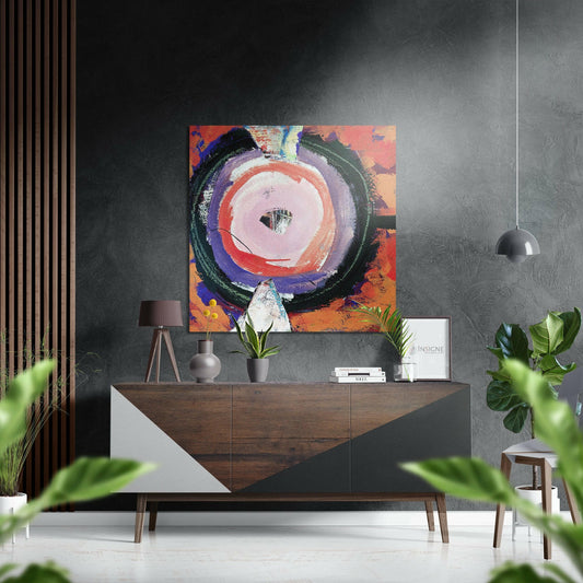 Modern interior with abstract circular artwork featuring red, purple, and black concentric circles displayed above a wooden console table with plants and pendant lighting.
