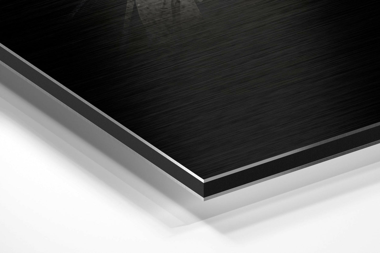 Close-up angled view of layered Dibond panel showing black brushed aluminium top surface with white backing layers.